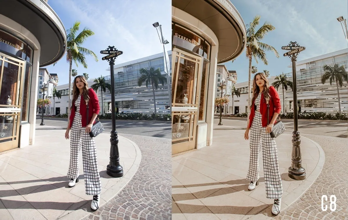 Mulher de calça xadrez e blazer vermelho posando em uma esquina ensolarada ao ar livre.