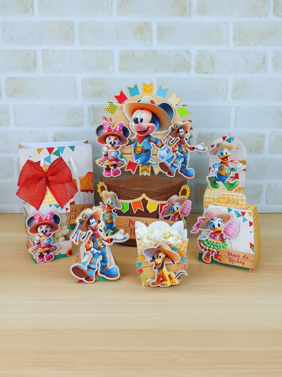 Arquivo de Corte Arraiá da Turma do Mickey Studio 1 Kit de festa com personagens clássicos vestidos com roupas caipiras coloridas sobre mesa de madeira.