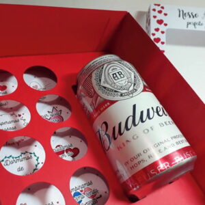 Caixa de presente vermelha com lata de cerveja e mensagens de amor.