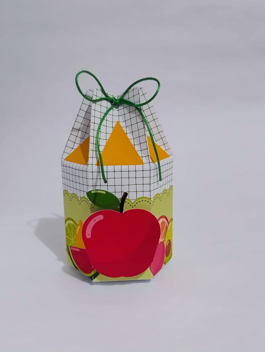 Arquivo de Corte Festa Frutinhas em Studio e PDF 2 Caixa de papel hexagonal decorada com frutas e laço verde em fundo branco.