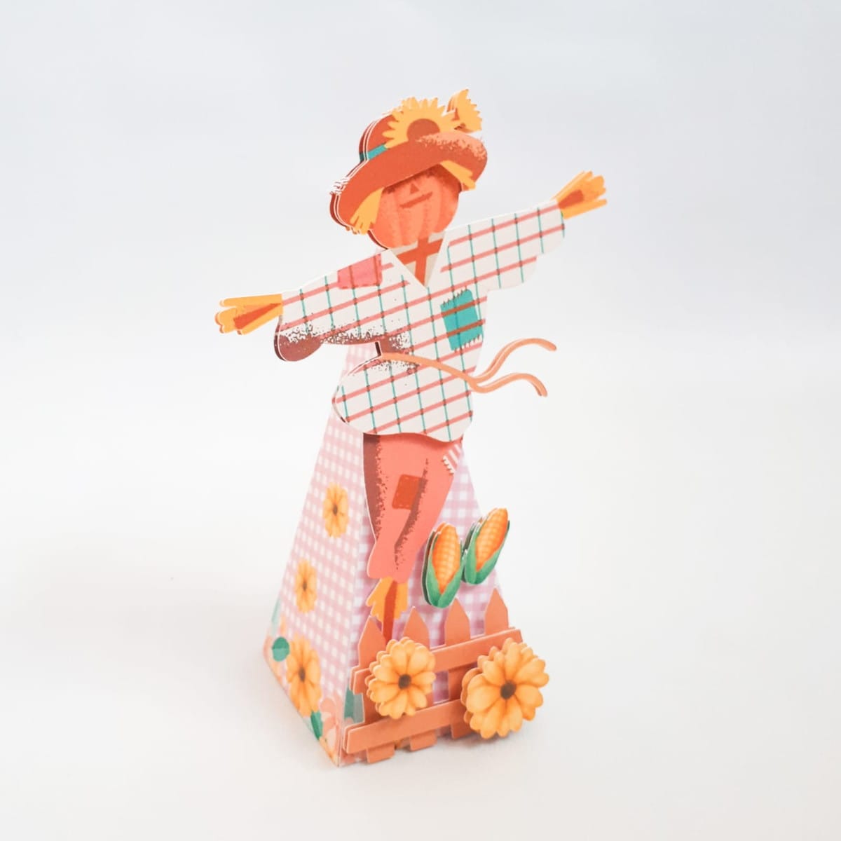 Arquivo de Corte Festa Junina Studio para Lembrancinhas 5 Espantalho de arte digital com chapéu, camisa xadrez, base cônica e decoração de milho e flores.