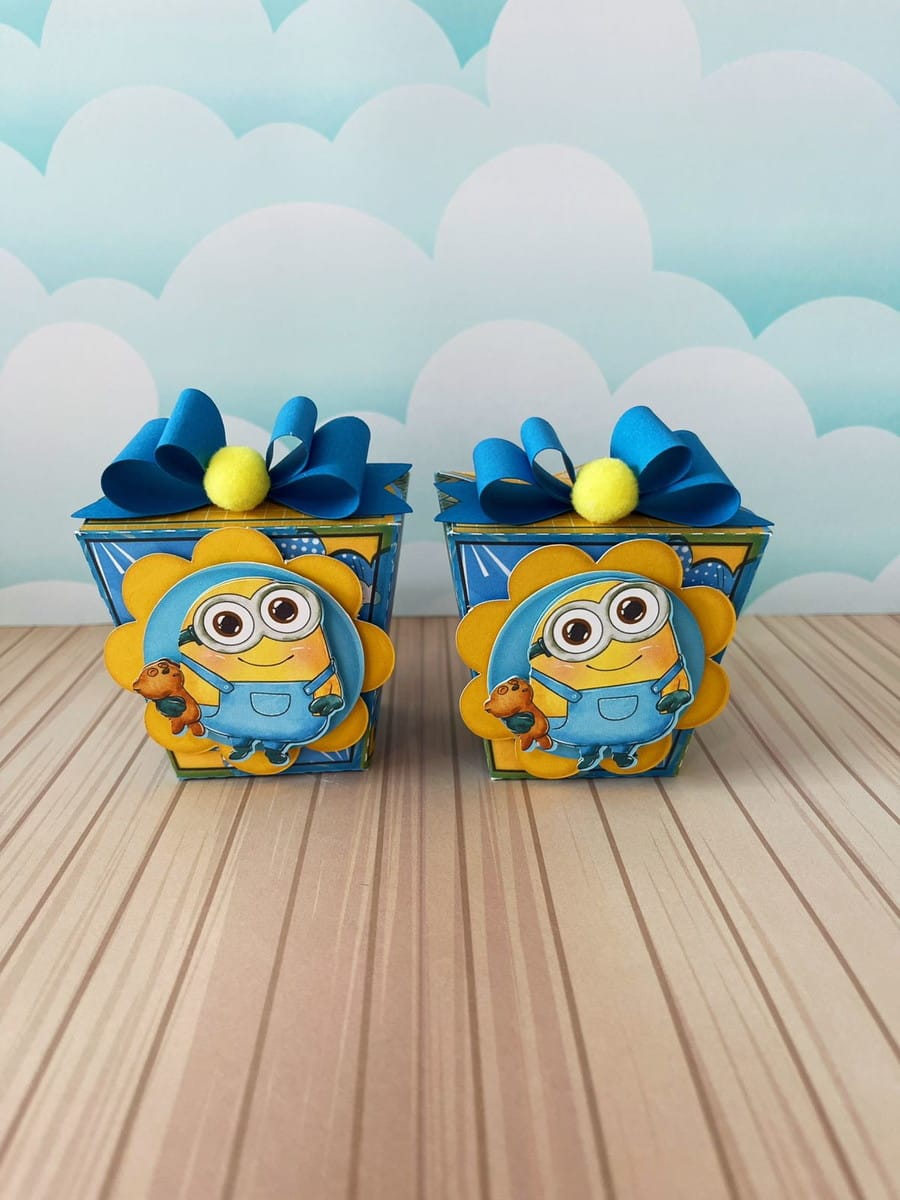 Arquivo de Corte Festa Minions Luxo em Studio e PDF 3 Duas caixas decoradas com personagem amarelo de óculos e laços azuis.
