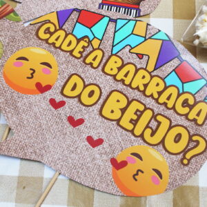 Adereço de festa junina com texto "CADE A BARRACA DO BEIJO?", emoticons e pipoca.