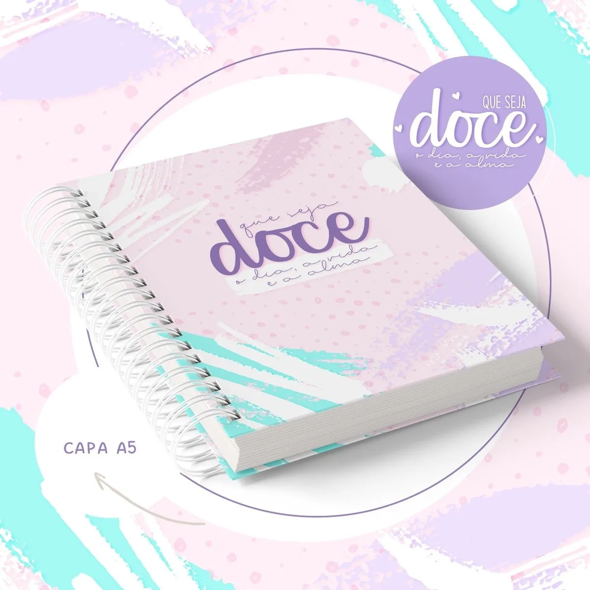 Caderno espiral com capa decorada em tons de rosa, azul e branco abstratos.