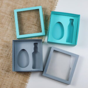 Molde caixa ovo 150g com mini bebida para lembrancinhas 17 Quatro caixas de presente abertas com moldes internos e tampas vazadas.