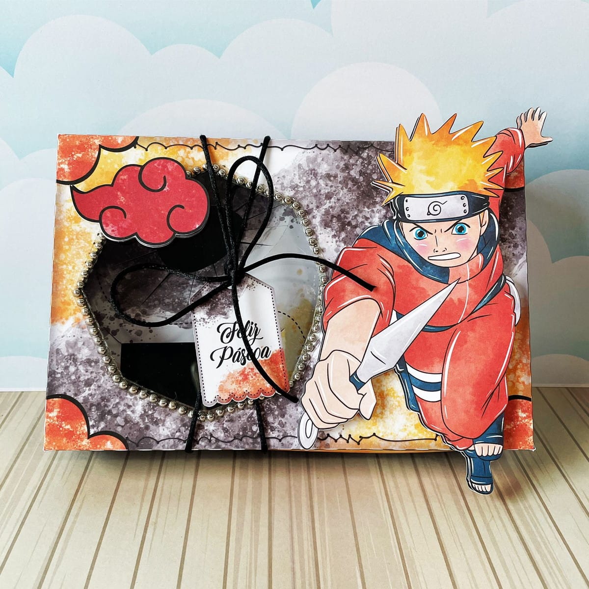 Caixa de Páscoa Naruto Kit Digital PDF PNG e Studio 4 Caixa de Páscoa decorada com personagem de anime e nuvem vermelha, laço preto.