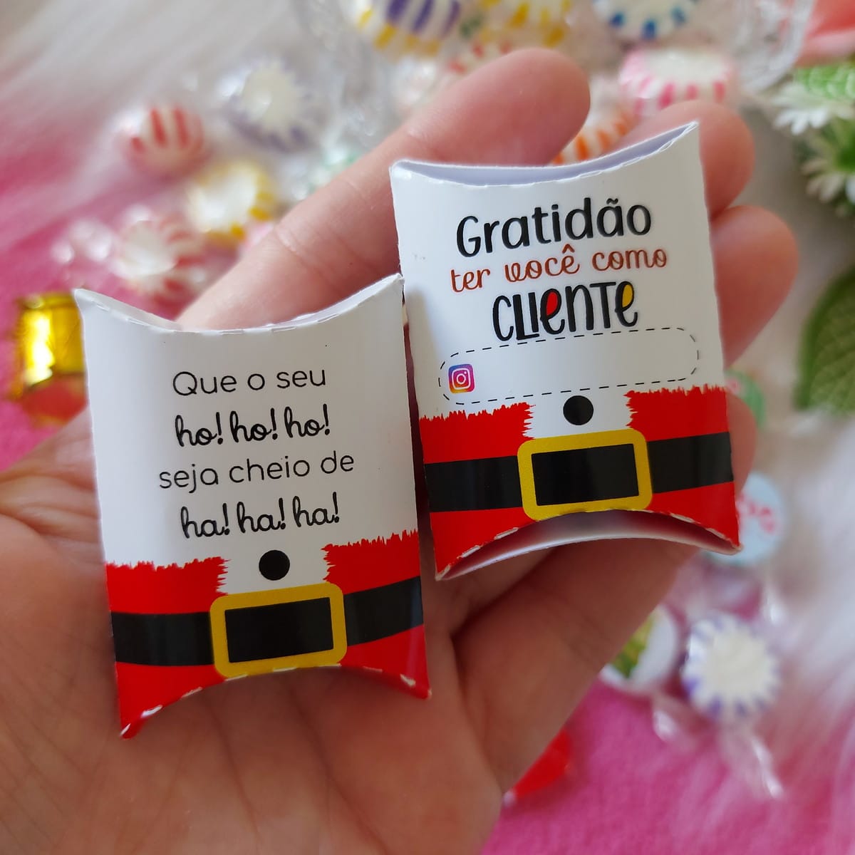 Caixinha Bala de Natal Arquivo Digital em PDF PNG e Studio 3 Duas caixinhas de papel natalinas, uma com mensagem de gratidão, outra com desejo festivo, seguradas por uma mão.