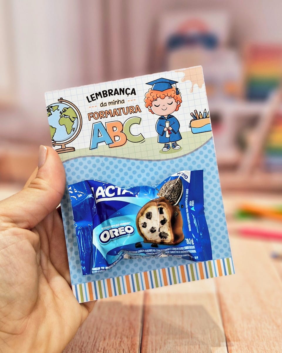 Card Bombom Formatura ABC PDF para Imprimir 2 Mão segurando cartão com desenho de formatura e um biscoito embalado colado.