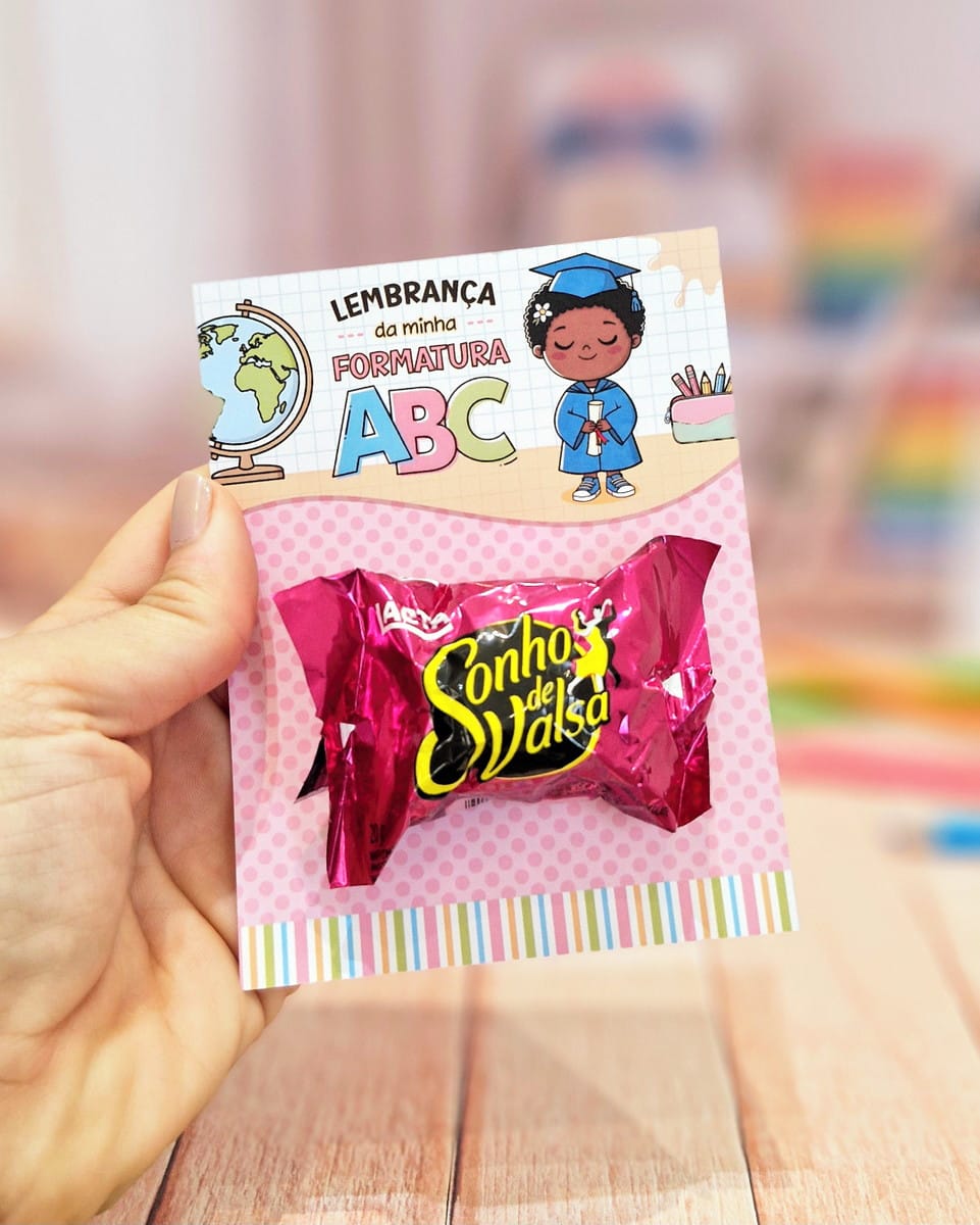 Card Bombom Formatura ABC PDF para Imprimir 1 Mão segurando um cartão decorado com bombom colado para formatura escolar infantil.