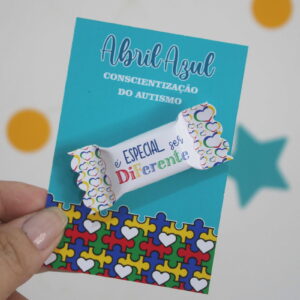 Arte digital de um cartão de conscientização do autismo com frase e símbolos.