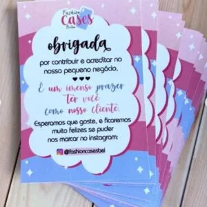 Pilha de cartões coloridos de agradecimento com mensagens impressas sobre fundo de madeira.