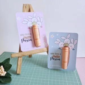 Cartões de Páscoa com desenhos de coelhos e cenouras de papel sobre cavalete madeira.