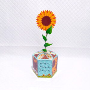 Design de girassol em papel, vaso hexagonal decorado, fundo branco.