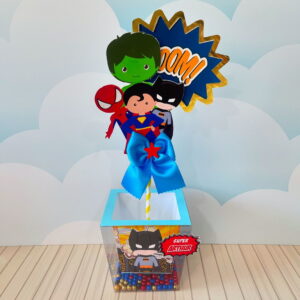 Centro de mesa super heróis digital em arquivo Studio e PDF 12 Design de centro de mesa com personagens de super-heróis e balão "Boom!", sobre base decorada.