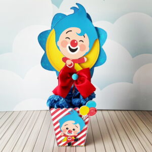 Design de centro de mesa com personagem de desenho animado sorridente e balões.