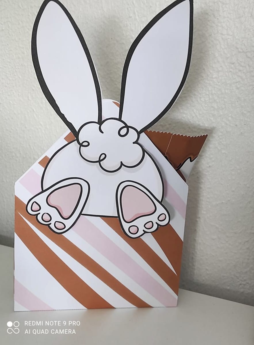 Envelope de Páscoa arquivo de corte para lembrancinha 2 Design da parte traseira de um coelho em embalagem listrada marrom e rosa.