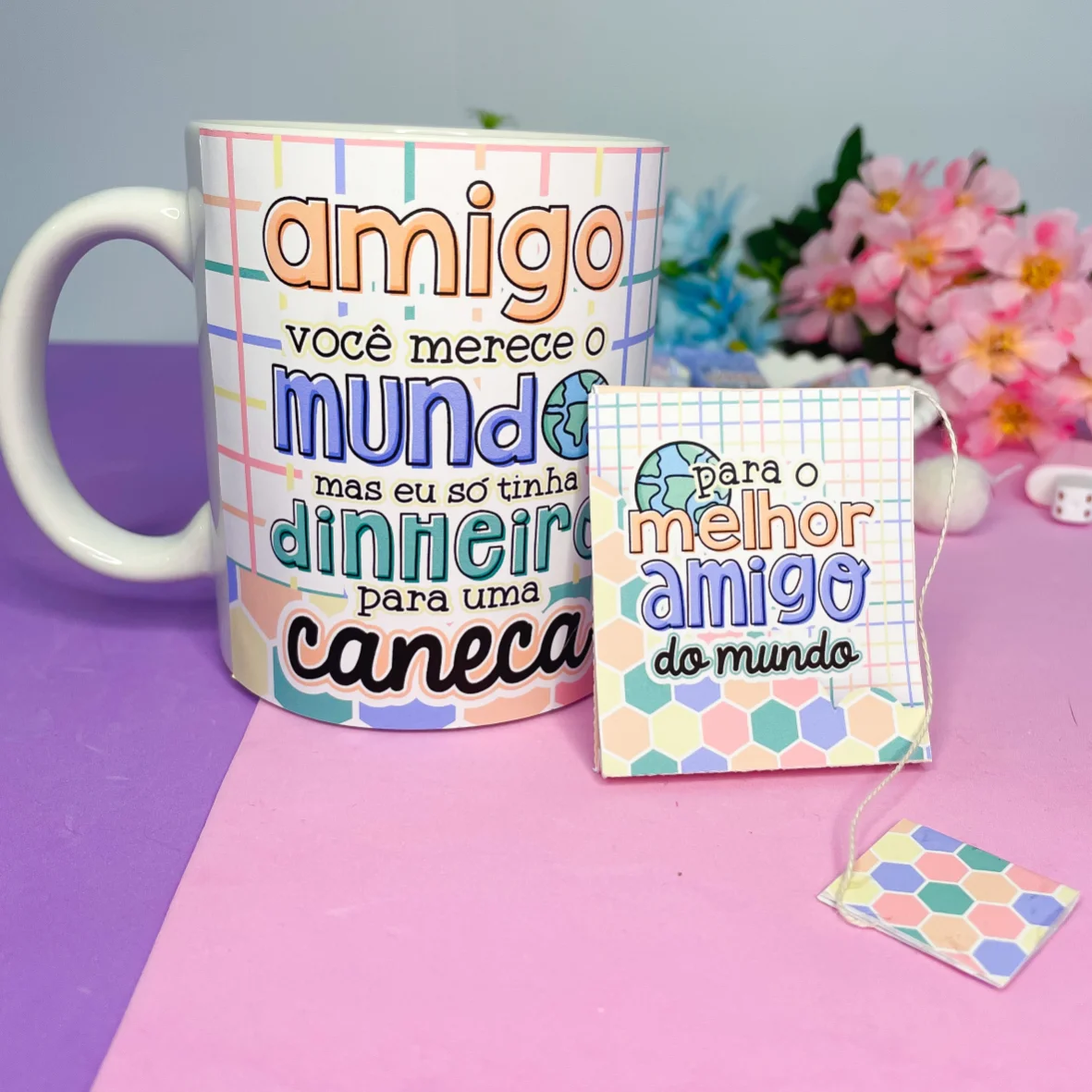 Caneca branca estampada e embalagem temática sobre fundo rosa e roxo.