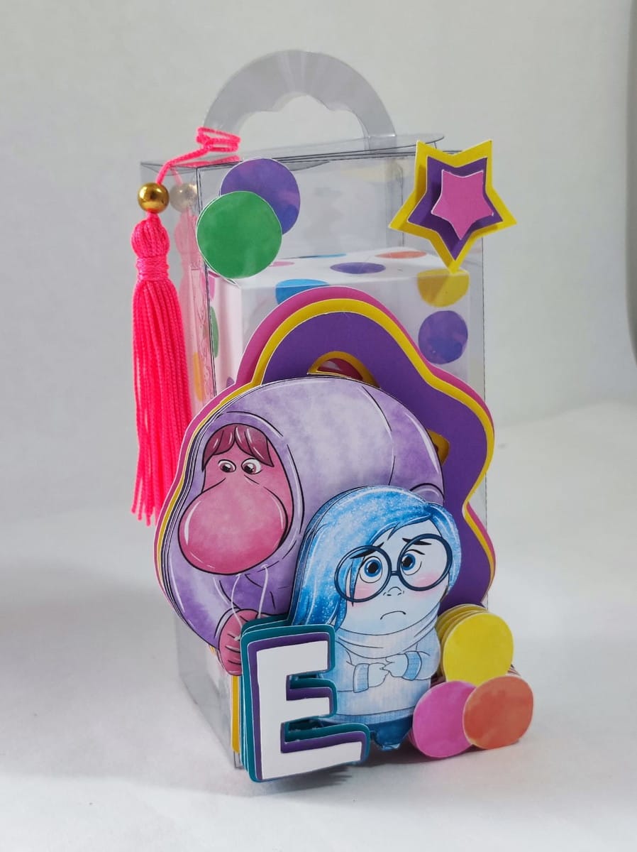 Kit Digital Festa Divertidamente Luxo com Studio e PDF 2 Caixa transparente decorada com figuras de desenho, letra "E", estrela e borla rosa.