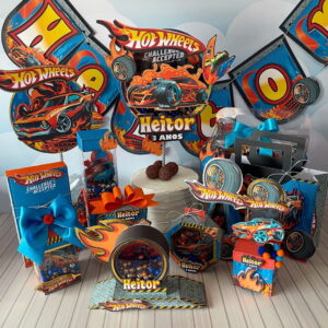 Decoração de festa com tema de carros de corrida, incluindo banner, caixas e bolo com designs vibrantes.