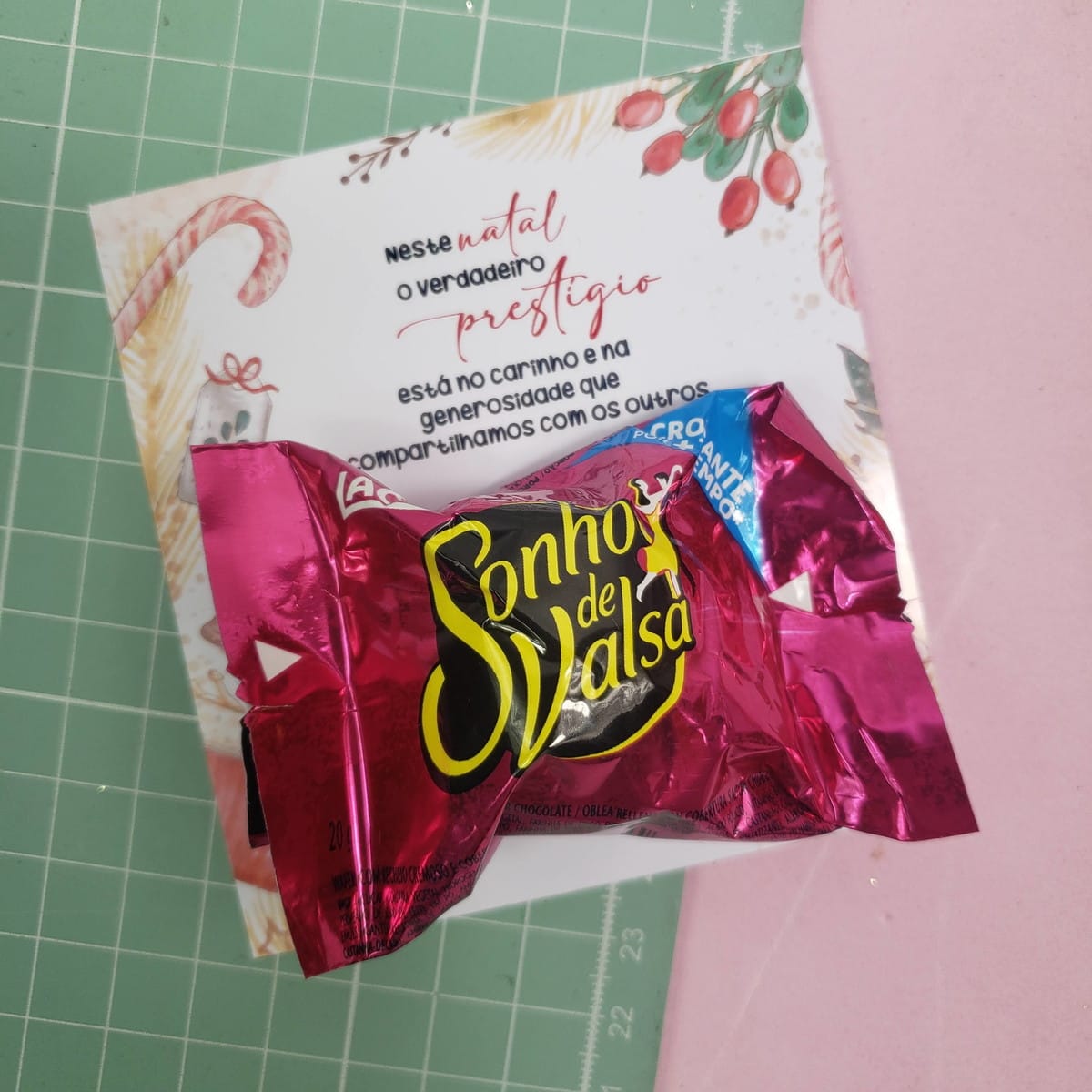 Kit Cards Doces Natal PNG para Lembrancinhas 1 Um bombom Sonho de Valsa rosa sobre um cartão de Natal com mensagem.