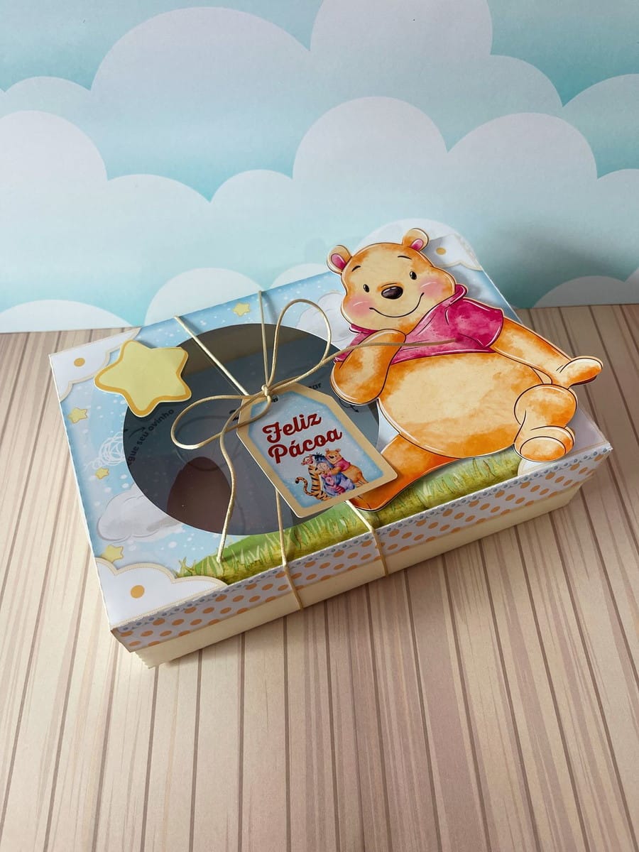 Kit da Caixa de Páscoa Ursinho Pooh para Corte e Impressão 2 Arte digital de caixa de Páscoa com personagem de urso, laço e etiqueta 'Feliz Páscoa'.