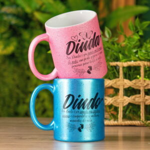 Duas canecas com glitter, rosa e azul, com mensagens "Dinda" e "Dindo".