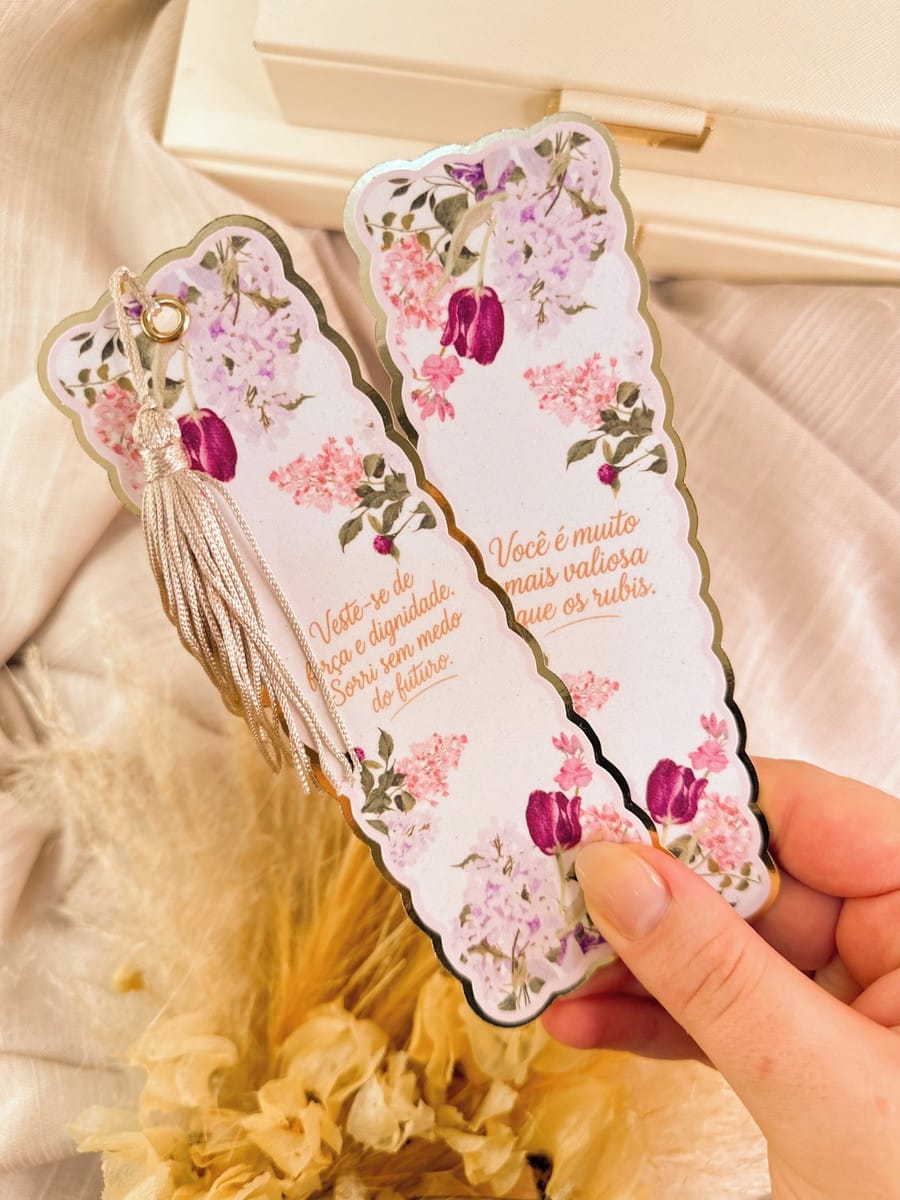 Kit Digital Dia da Mulher Cristão para Personalizados 4 Mão segurando dois marcadores de página decorados com flores roxas e frases.