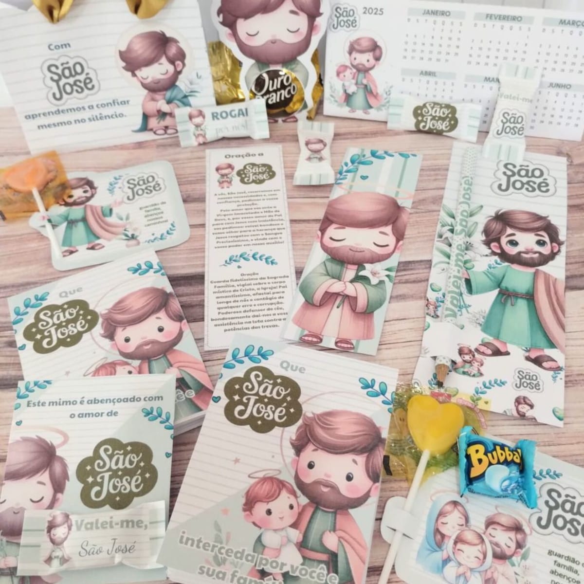 Kit Digital Lembrancinha São José para Imprimir e Cortar 1 Coleção de itens de papelaria e doces ilustrados dispostos sobre uma mesa de madeira.
