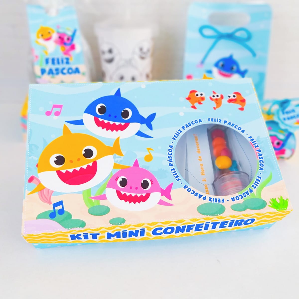 Kit digital Páscoa Baby Shark com caixas e sacolinhas 3 Design de Páscoa com tubarões coloridos, notas musicais e doces em arte digital.