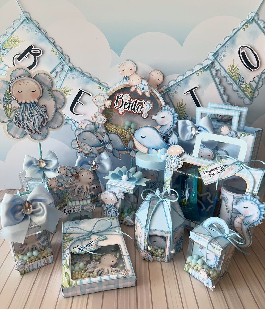 Kit Festa Fundo do Mar Azul com Studio e PDF 1 Decoração de festa infantil com tema marinho, caixas e baleias em tons azuis.