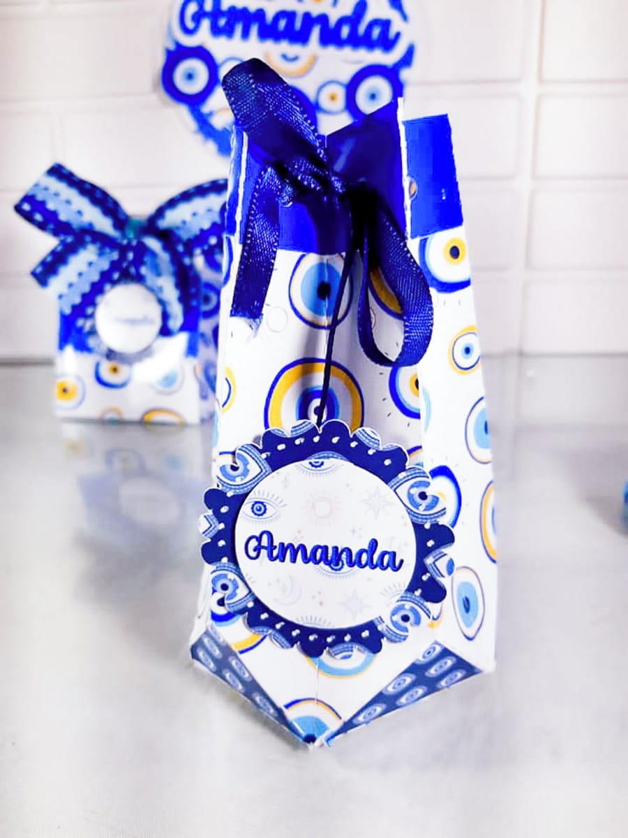 Kit Festa Olho Grego Digital para Imprimir e Cortar 4 Design de caixa de presente com padrão olho grego azul e amarelo, fita azul.