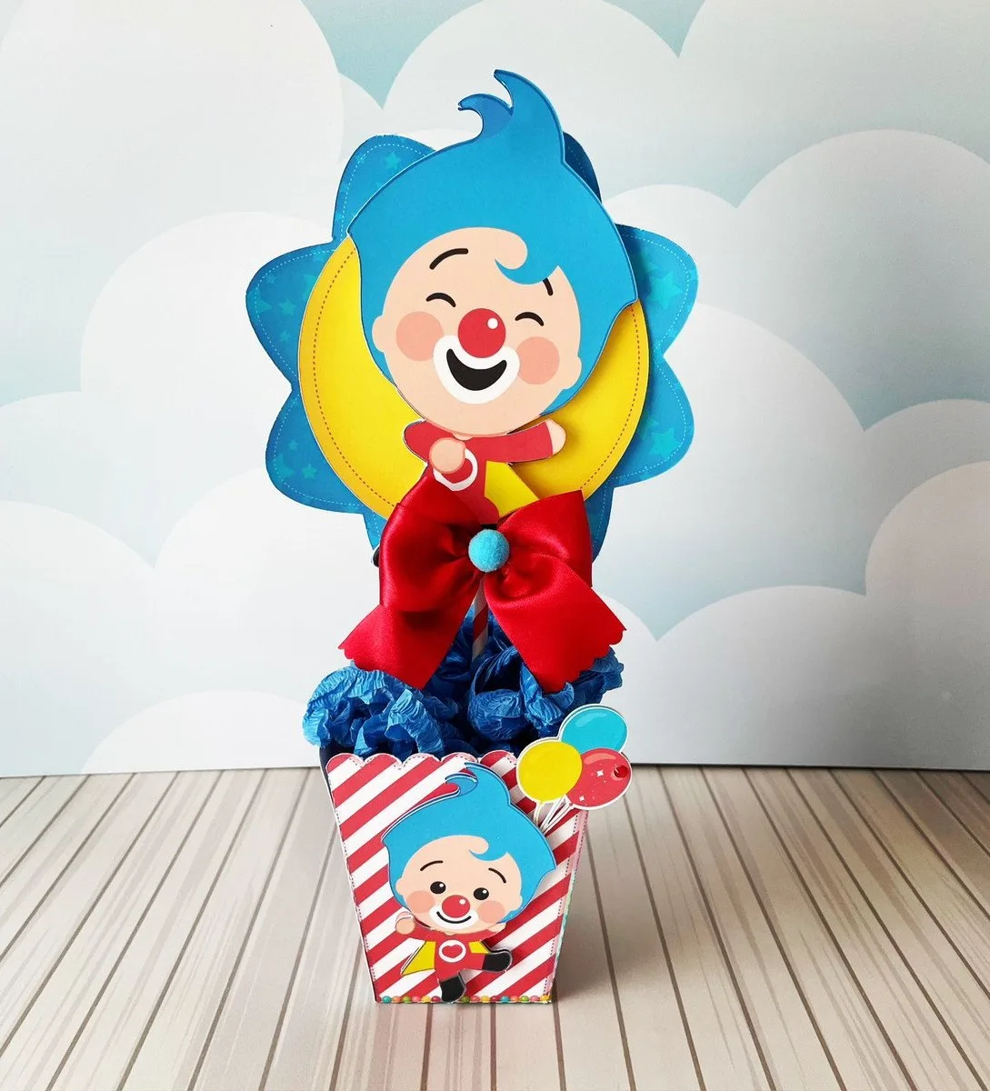 Topo de bolo com personagem de cabelo azul e laço vermelho grande
