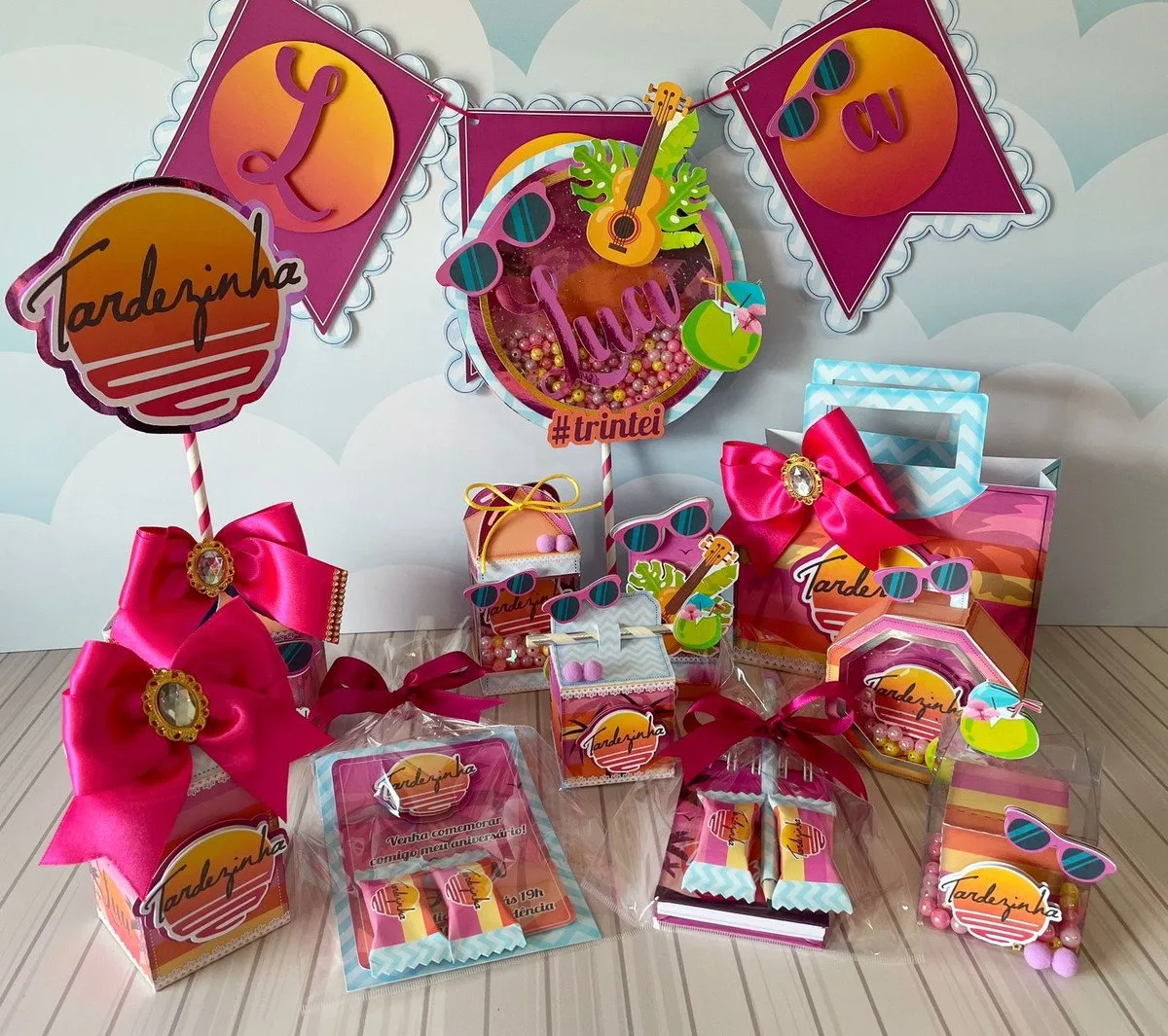 Decoração de festa com tema tropical colorida contendo lembrancinhas, caixas personalizadas e ornamentos suspensos.