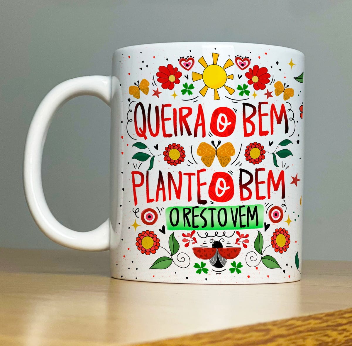 Kit Sublimação Caneca Proteção com 32 Artes em PNG 3 Caneca branca estampada com ilustrações coloridas e frases motivacionais em português.