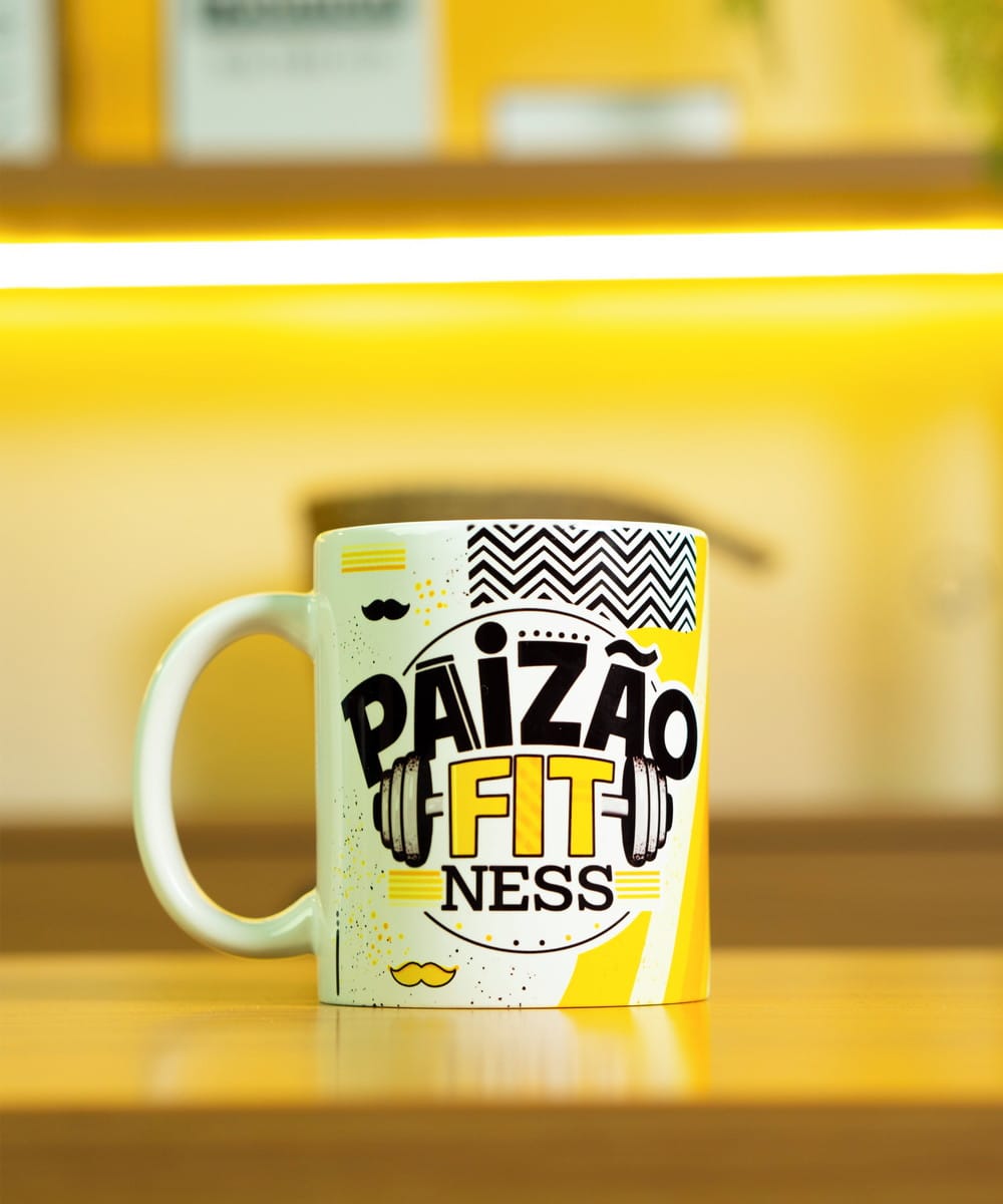 Kit Sublimação Dia dos Pais PNG para Canecas e Camisetas 2 Caneca branca estampada com letras pretas e amarelas sobre mesa de madeira.