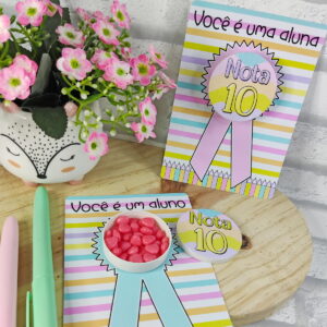 Arte digital de cartões 'Nota 10' para alunos, com fitas, flores e canetas.