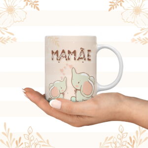 Caneca branca com ilustração de dois elefantes e texto "MAMÃE", sobre fundo suave.