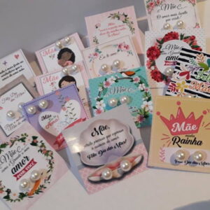 Várias cartelas de brincos de pérola para o Dia das Mães, com mensagens e designs variados.